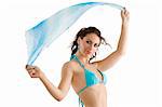 young and stunning brunette wearing a sky-blue swimsuit with scarf playing with wind