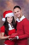 happy young couple with christmas clothes and box gift