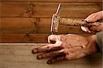 Carpenter hands with hammer wood and nail on wooden background