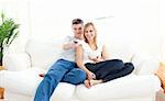 Adorable couple using a remote in the living-room at home