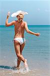 Young woman in bikini running on the beach