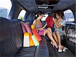 woman in limousine showing new dress to her friend. Horizontal shape, full length, copy space