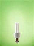 fluorescent lightbulb on green background. Vertical shape, copy space