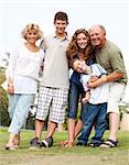 Affectionate family of five posing outdors on sunny day