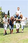 Happy family playing in the park with three children