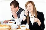 Ambitious businesswoman talking on phone while havin breakfast with her husband at home