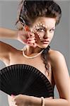 young naked woman with hair style and beautiful fashion make up covering brest with a black fun