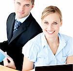 Beautiful couple of businesspeople smiling at camera using laptop  against white background