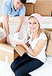 Animated young couple packing a box at home