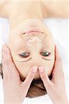 Cute young woman enjoying a facial massage in a health spa