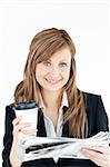 Elegant businesswoman reading newspaper holding coffee against white background