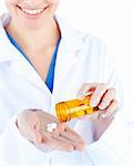 Close-up young female doctor holding pills against white background