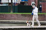 Girl walking with her dog on the leash. Beagle puppy