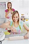 Smiling female friends baking pastry in the kitchen at home