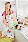 Positive young woman baking cookies in the kitchen at home