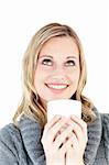 Thoughtful woman enjoying a hot coffee standing against a white background