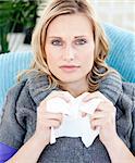 Kranke Frau mit einem Papiertaschentuch sitzen auf einem Sofa zu Hause