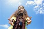hippie girl on blue sky background, sunny light f/x, focus point on face