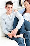 Nice boyfriend massaging his girlfriend's feet on the sofa at home