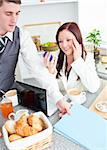 Couple of businesspeople having breakfast in the kitchen at home