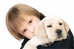 Young child holding a Labrador retriever puppy