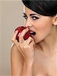 Portrait of beautiful woman, she bites red apple