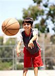 Young boy in action passing basketball