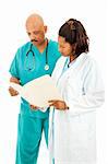 Two attractive African American doctors reading a patient's medical chart.  Isolated on white.