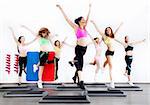 group of women doing aerobics on stepper in gym