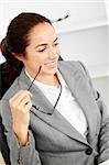 Charismatic hispanic businesswoman holding glasses sitting at her desk in her office