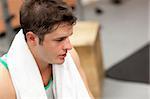 Exhausted male athlete with a towel after working out