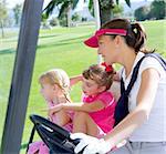 golf course family mother and daughters in buggy green grass field