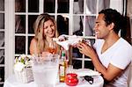 A happy couple sharing a bottle of wine in an outdoor cafe in Europe