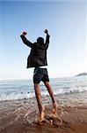 A business man jumping on the beach, freedom, success concept