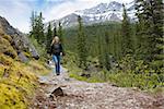 A happy woman walking on a path on a mountain hike in Banff National Park