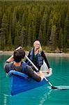 A happy couple canoeing on a glacial lake