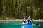 A portrait of a happy copule in a canoe on a glacial lake