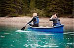 A man and woman paddling in a canoe on a lake