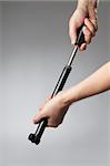 A compact hand-operated black plastic bicycle pump