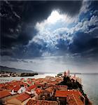 A medieval town with a dramatic storm filled sky