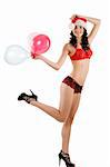 young beautiful girl wearing sexy lingerie and a christmas hat posing and playing with balloons