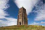 Tourists exploring the ruins of St. Michael's Tower at the top of glastonbury tor in sommerest england