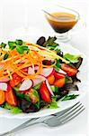 Plate of healthy green garden salad with fresh vegetables served with balsamic dressing