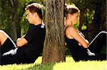 A picture of a young couple sitting in the park and being in a conflict