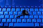Key rests upon computer keyboard , blue background