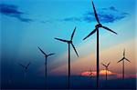 Wind turbine farm with rays of light at sunset