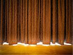 Gold curtains with light from a stage