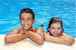 teen boy and little girl summer vacation in blue swimming pool