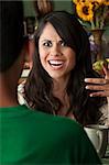 Angry Latina Woman at table in Kitchen with Coffee or Tea and Male Companion