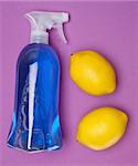 Vibrant cleaning liquid with lemons on a purple background.